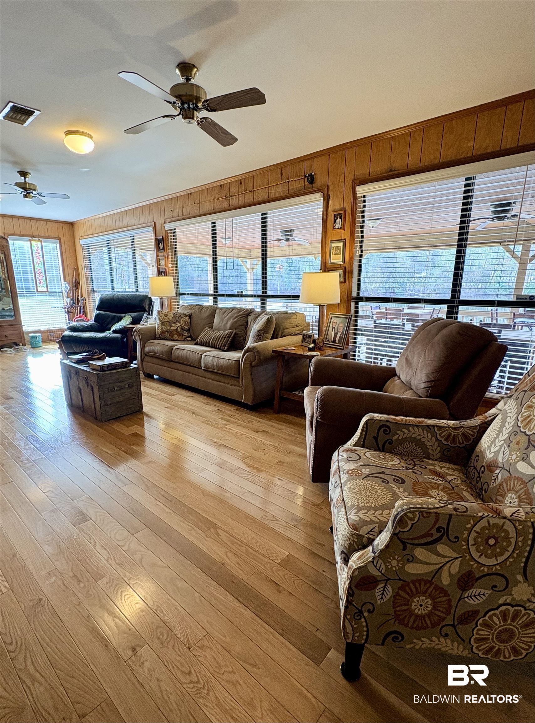 44 Ridge Road Castleberry, AL 36432 - Photo 3 of 33 Living room with a ceiling fan, light wood finished floors, and wood walls