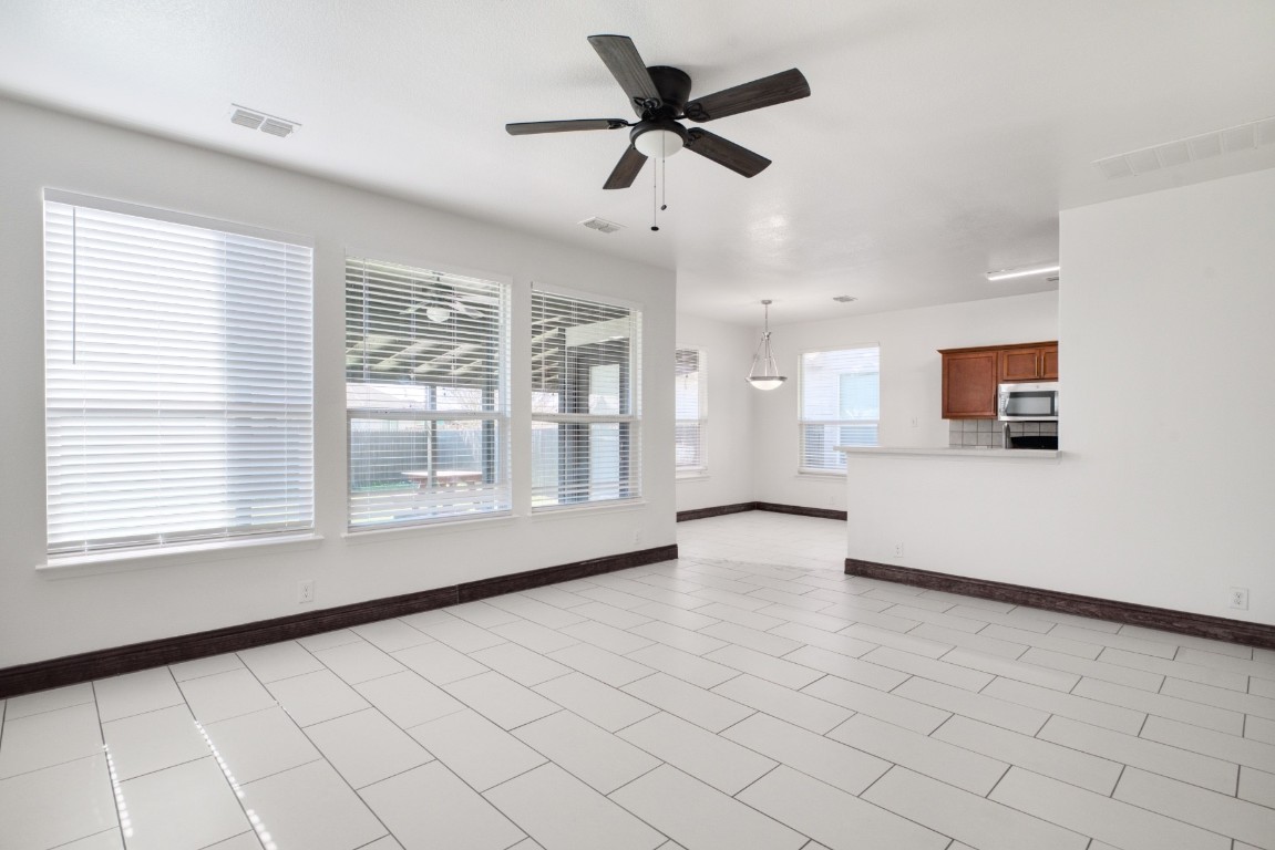 a view of an empty room and window and a kitchen