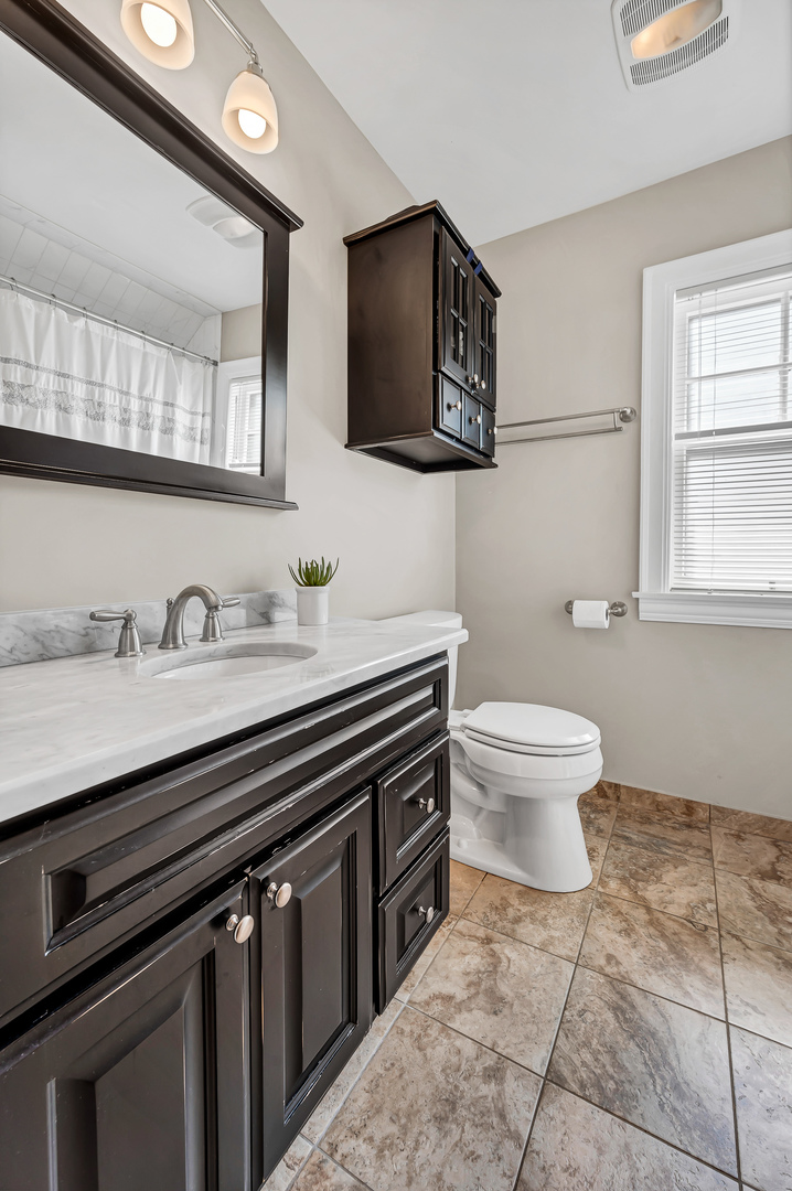 100 South Herbert Road Riverside, IL 60546 - Photo 27 of 30 a bathroom with a sink a toilet and mirror
