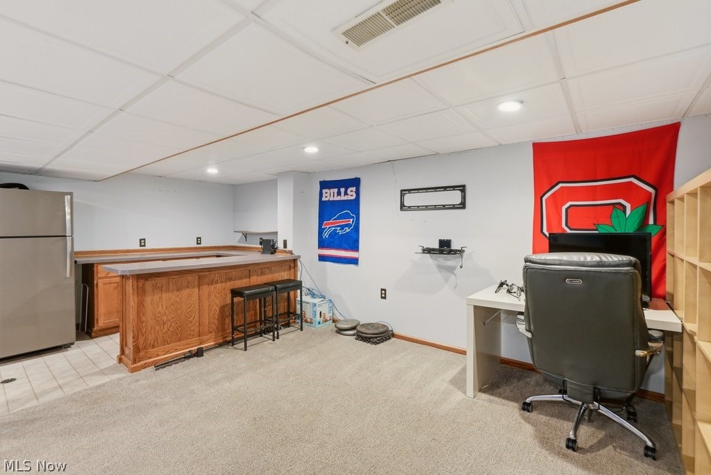 5321 Young Road Stow, OH 44224 - Photo 36 of 37 Finished basement space featuring a built-in wood-paneled bar with countertop, recessed lighting, drop ceiling, and mixed flooring with carpet and tile sections