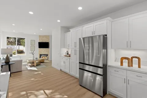a kitchen with stainless steel appliances a refrigerator sink and white cabinets