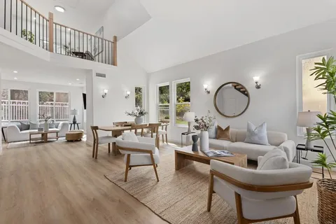 a living room with furniture a rug and a window