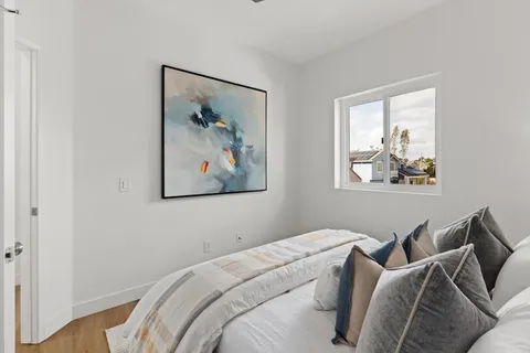 a bedroom with a bed and a painting on the wall