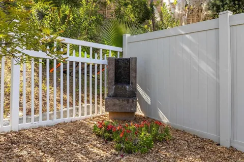 a view of a house with a small yard and wooden fence
