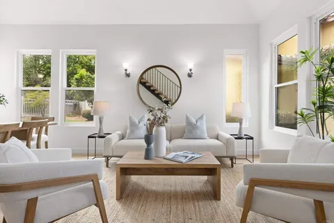 a living room with furniture a large window and a large mirror