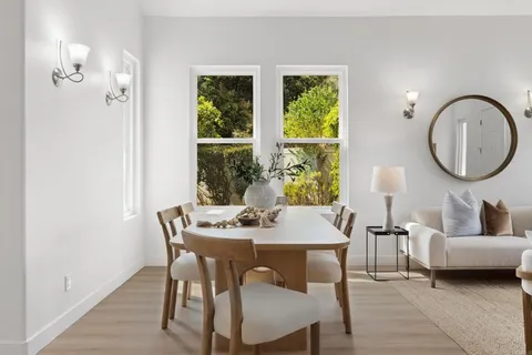 a view of a dining room with furniture and a large window