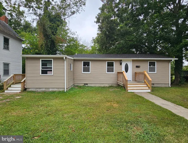 a view of a house with backyard and chairs