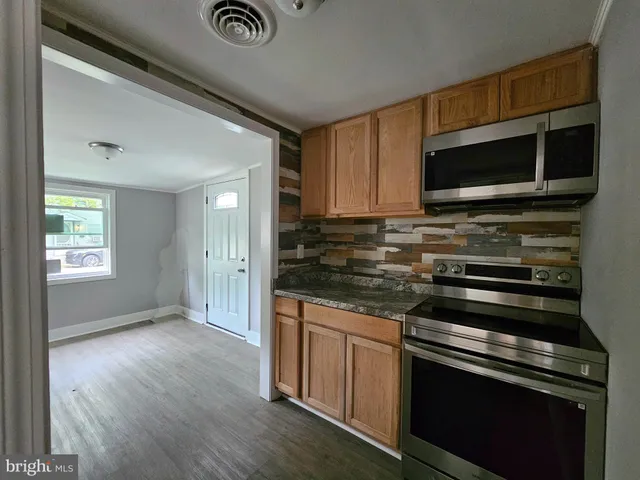 a kitchen with granite countertop a stove and a microwave