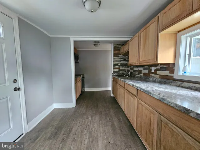 a kitchen with stainless steel appliances granite countertop a refrigerator a sink and white cabinets