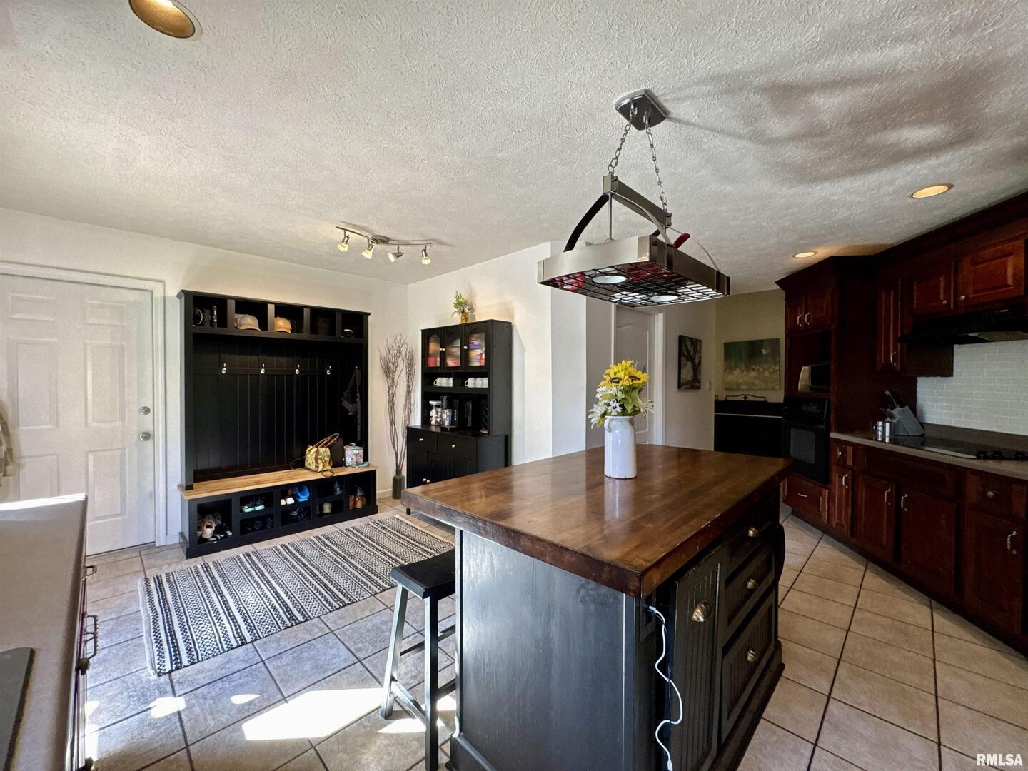 1801 Colonial Drive Marion, IL 62959 - Photo 17 of 45 a kitchen with stainless steel appliances granite countertop a stove a refrigerator a sink a dining table and chairs with wooden floor