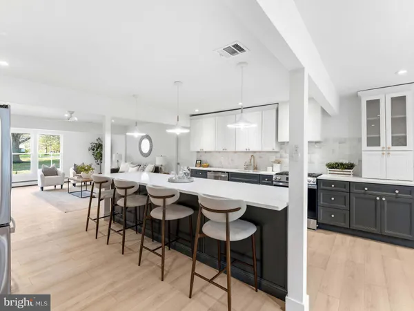 a dining room with furniture a potted plant and a large window