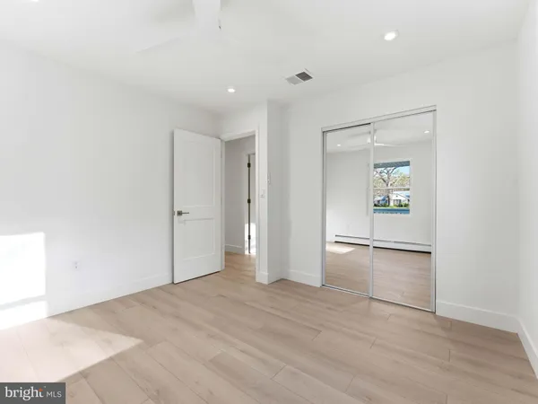 a view of an empty room with wooden floor and stairs