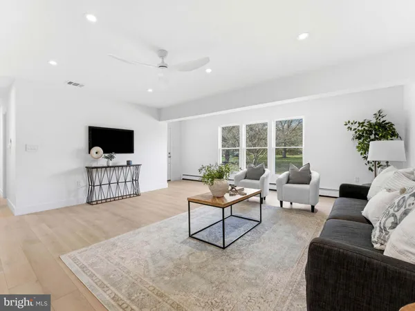 a kitchen with stainless steel appliances kitchen island granite countertop a table chairs sink and cabinets