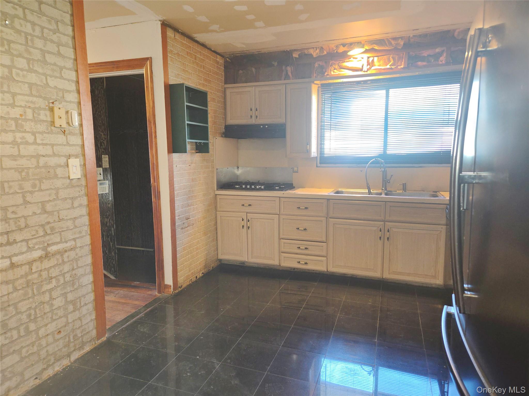 86 Decatur Street Roosevelt, NY 11575 - Photo 12 of 30 a kitchen with stainless steel appliances granite countertop a refrigerator and a sink