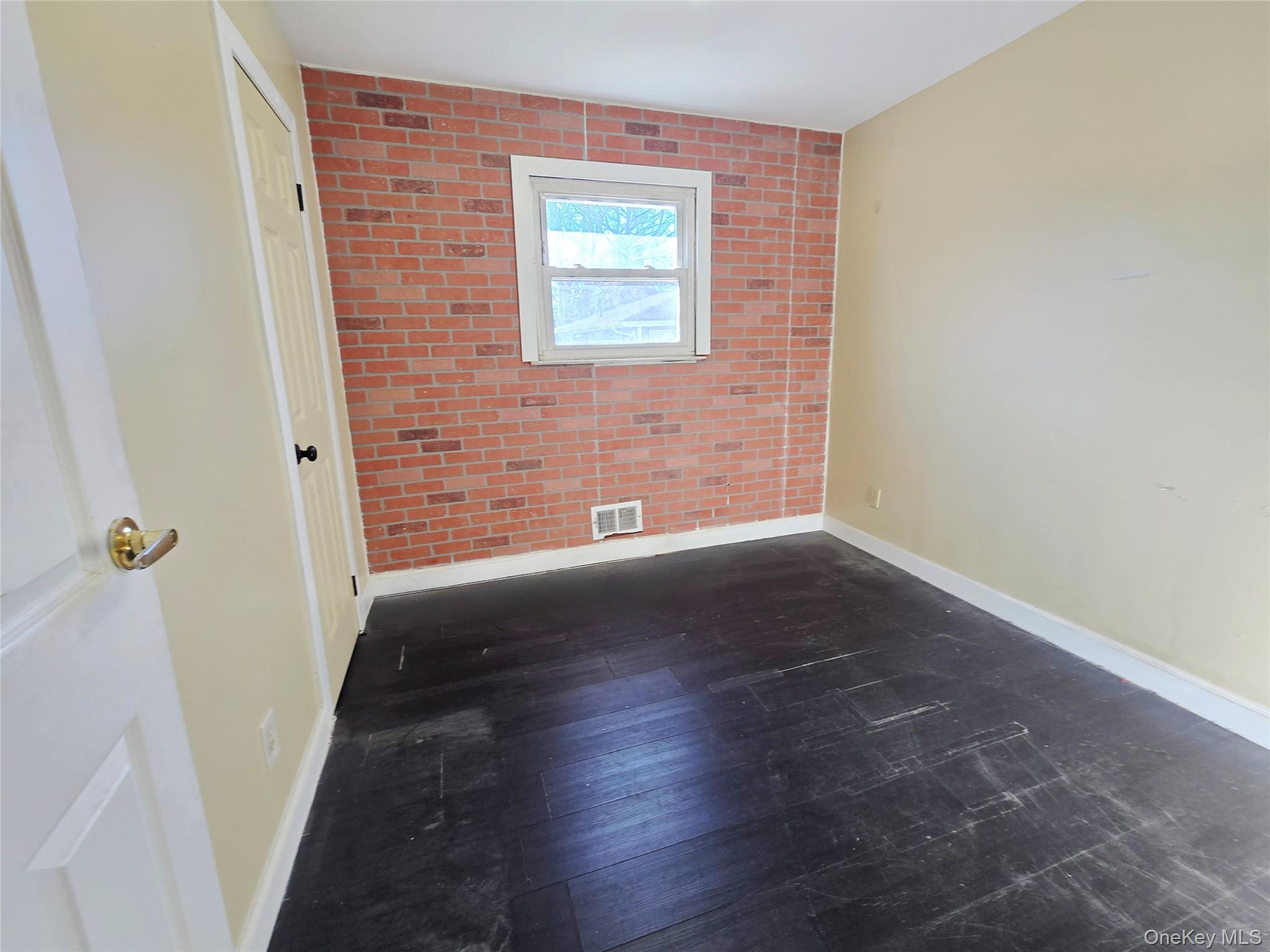 86 Decatur Street Roosevelt, NY 11575 - Photo 17 of 30 a view of an empty room with wooden floor and a window