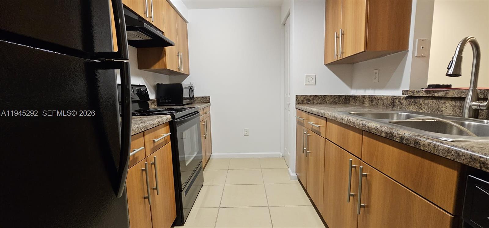 5800 West Sample Road, Unit 103 Coral Springs, FL 33067 - Photo 5 of 18 a kitchen with a sink stove and cabinets