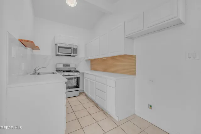 a kitchen with white cabinets and white appliances