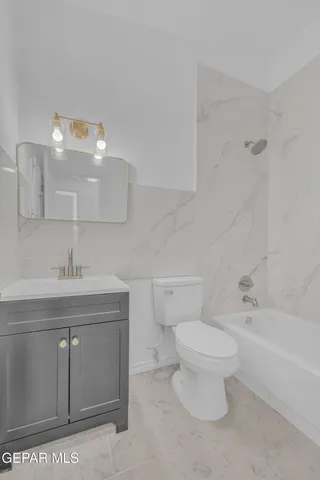 a white toilet sitting next to a bath tub and a shower