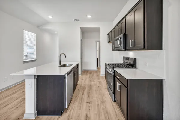 a kitchen with stainless steel appliances granite countertop a sink stove and refrigerator