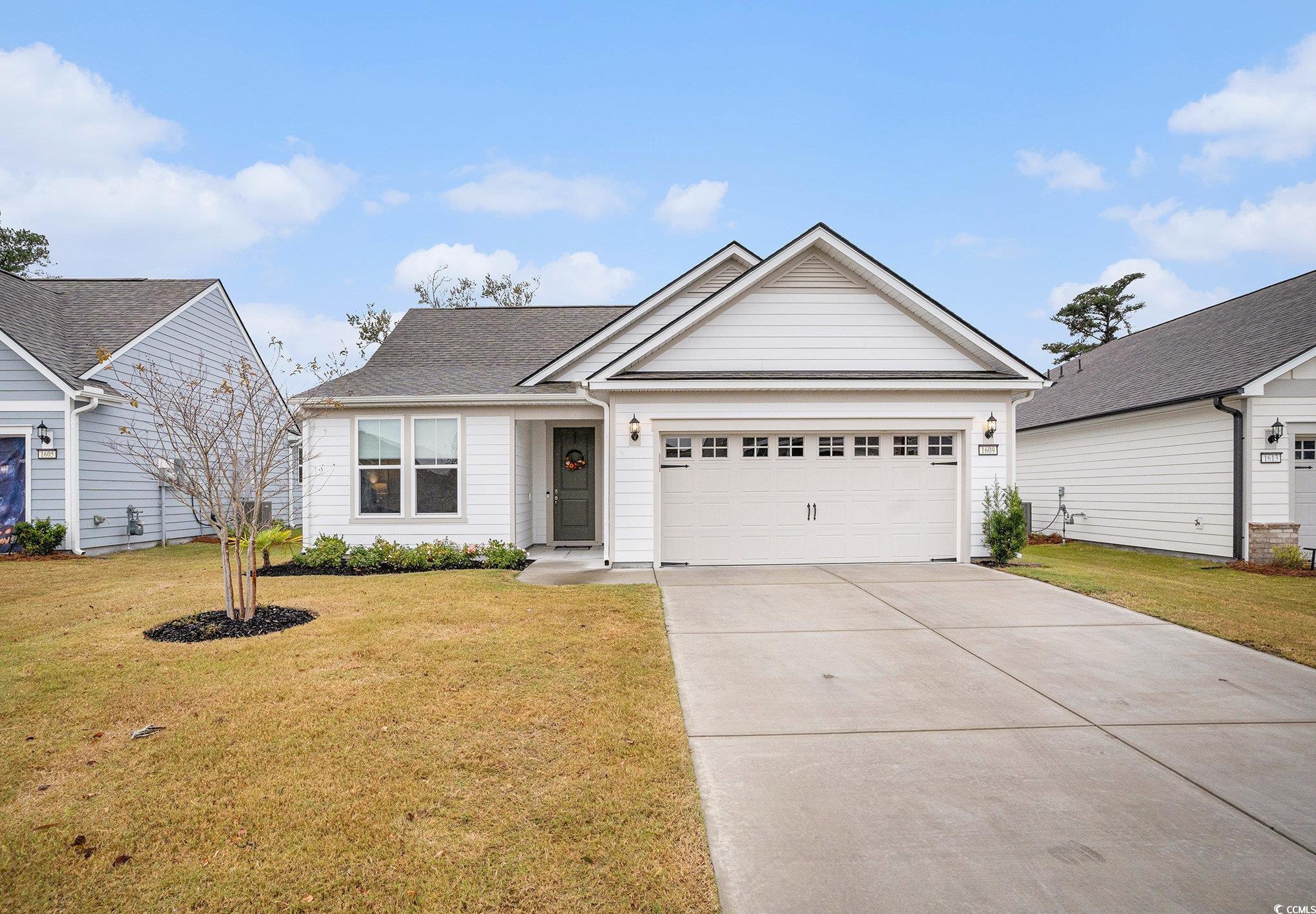 1609 Littleleaf Loop North Myrtle Beach, SC 29582 - Photo 1 of 40 View of front facade featuring driveway, an attached garage, a front yard, and roof with shingles