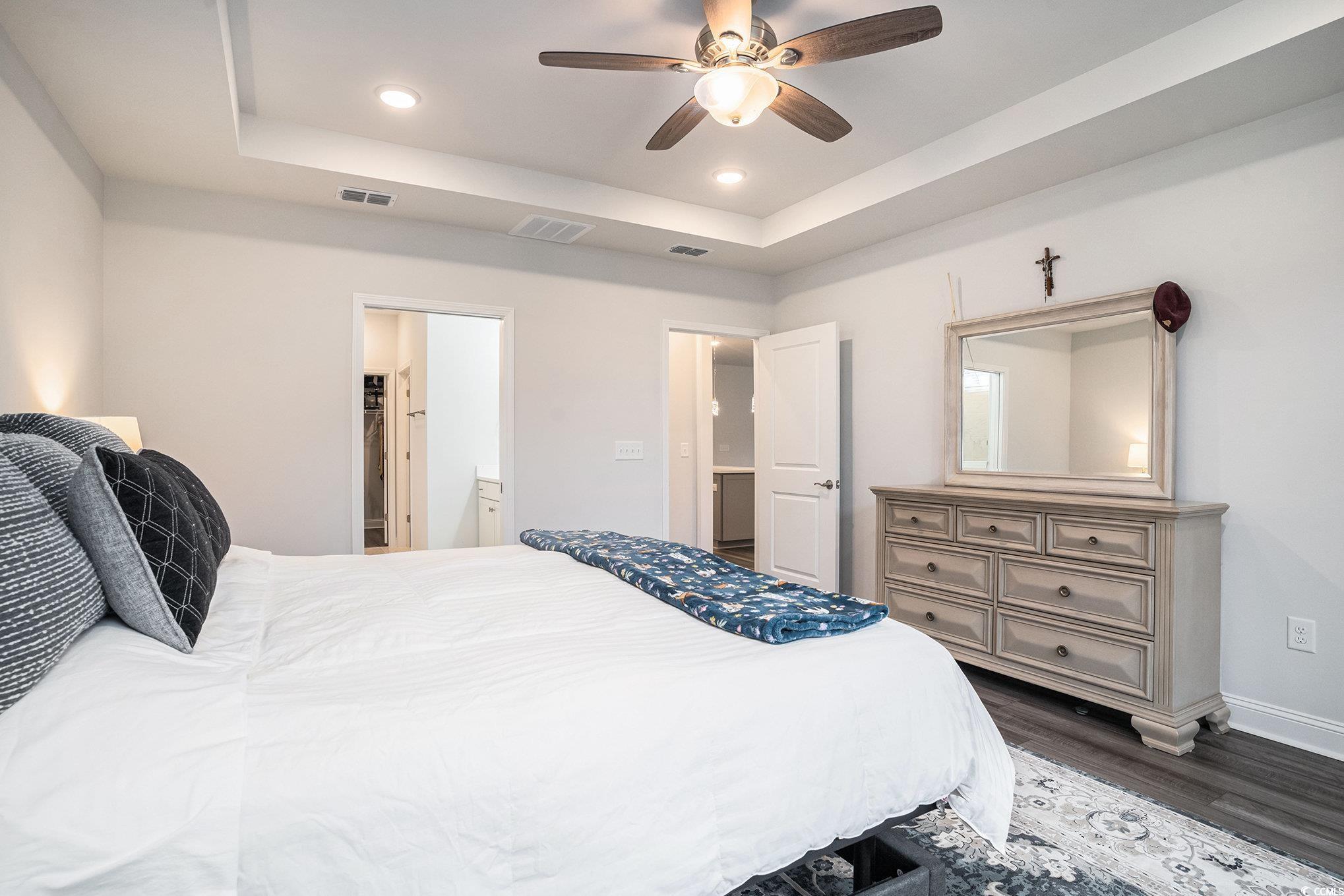 1609 Littleleaf Loop North Myrtle Beach, SC 29582 - Photo 17 of 40 Bedroom with recessed lighting, dark wood-type flooring, a raised ceiling, ceiling fan, and connected bathroom