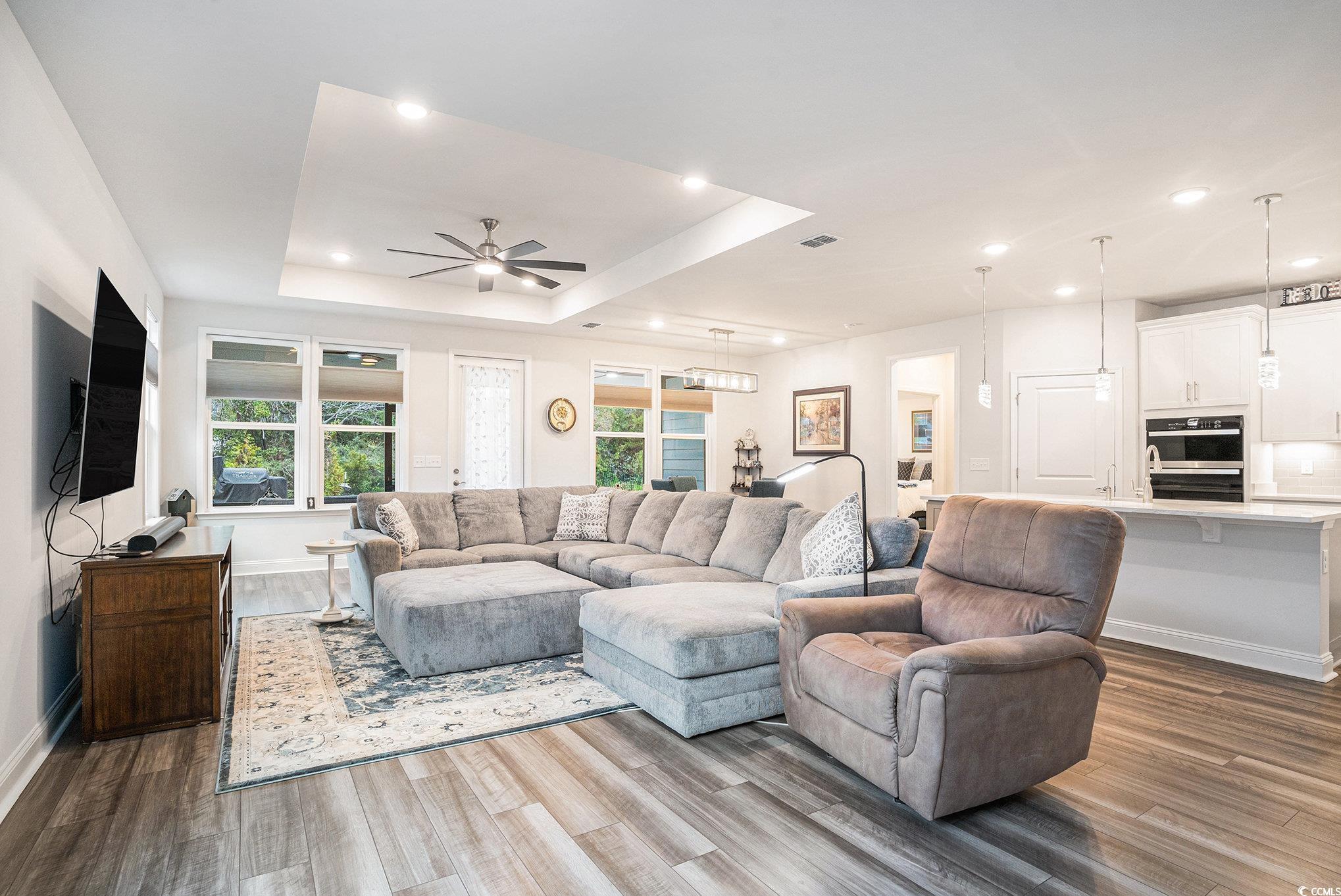 1609 Littleleaf Loop North Myrtle Beach, SC 29582 - Photo 6 of 40 Living area with a raised ceiling, dark wood-style flooring, recessed lighting, and a ceiling fan