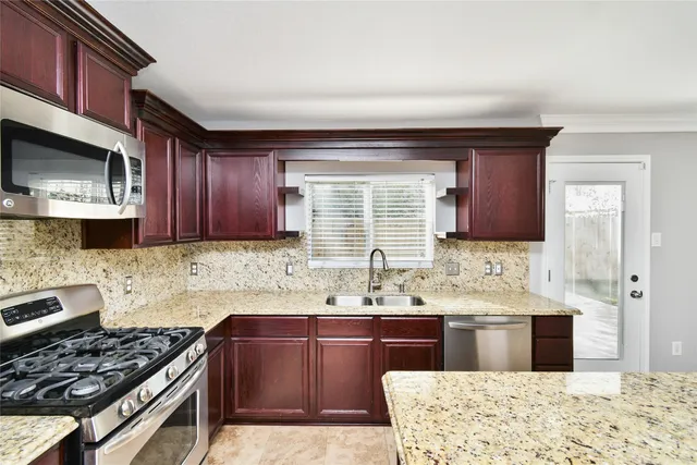 a kitchen with stainless steel appliances kitchen island granite countertop a sink stove and cabinets