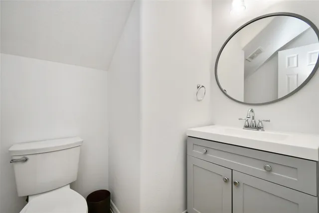 a bathroom with a toilet a sink and mirror