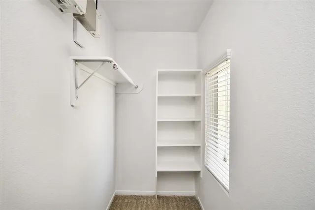 a view of walk in closet with empty racks