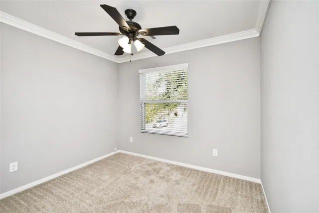 an empty room with a window and a ceiling fan