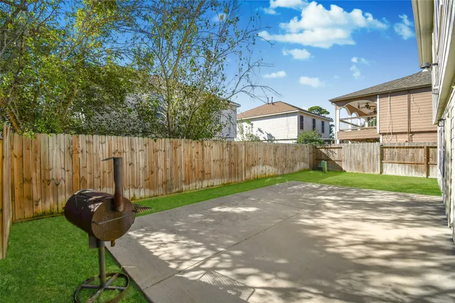 a view of a backyard with table and chairs and a large tree