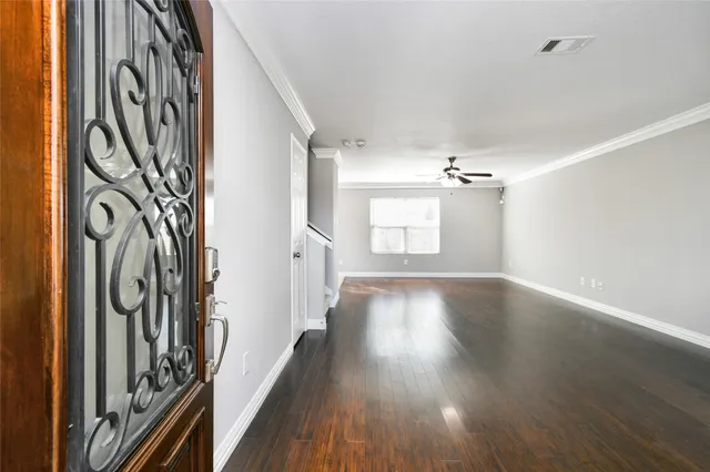 a view of a hallway with wooden floor and staircase