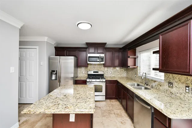 a kitchen with stainless steel appliances granite countertop sink stove refrigerator and cabinets