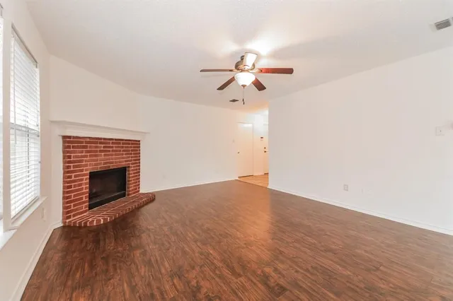 a view of empty room with wooden floor and fireplace