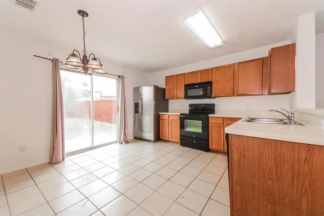 a kitchen with stainless steel appliances granite countertop a refrigerator oven a sink dishwasher and white cabinets with wooden floor