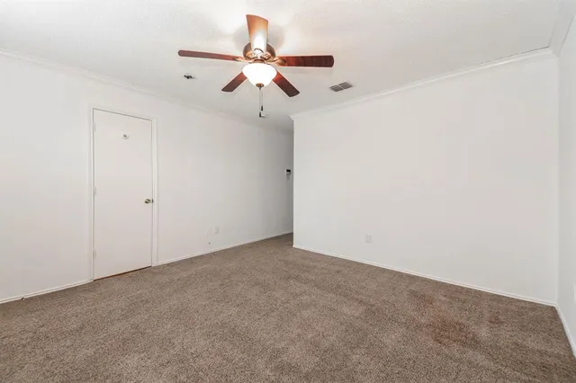 an empty room with a window and a ceiling fan
