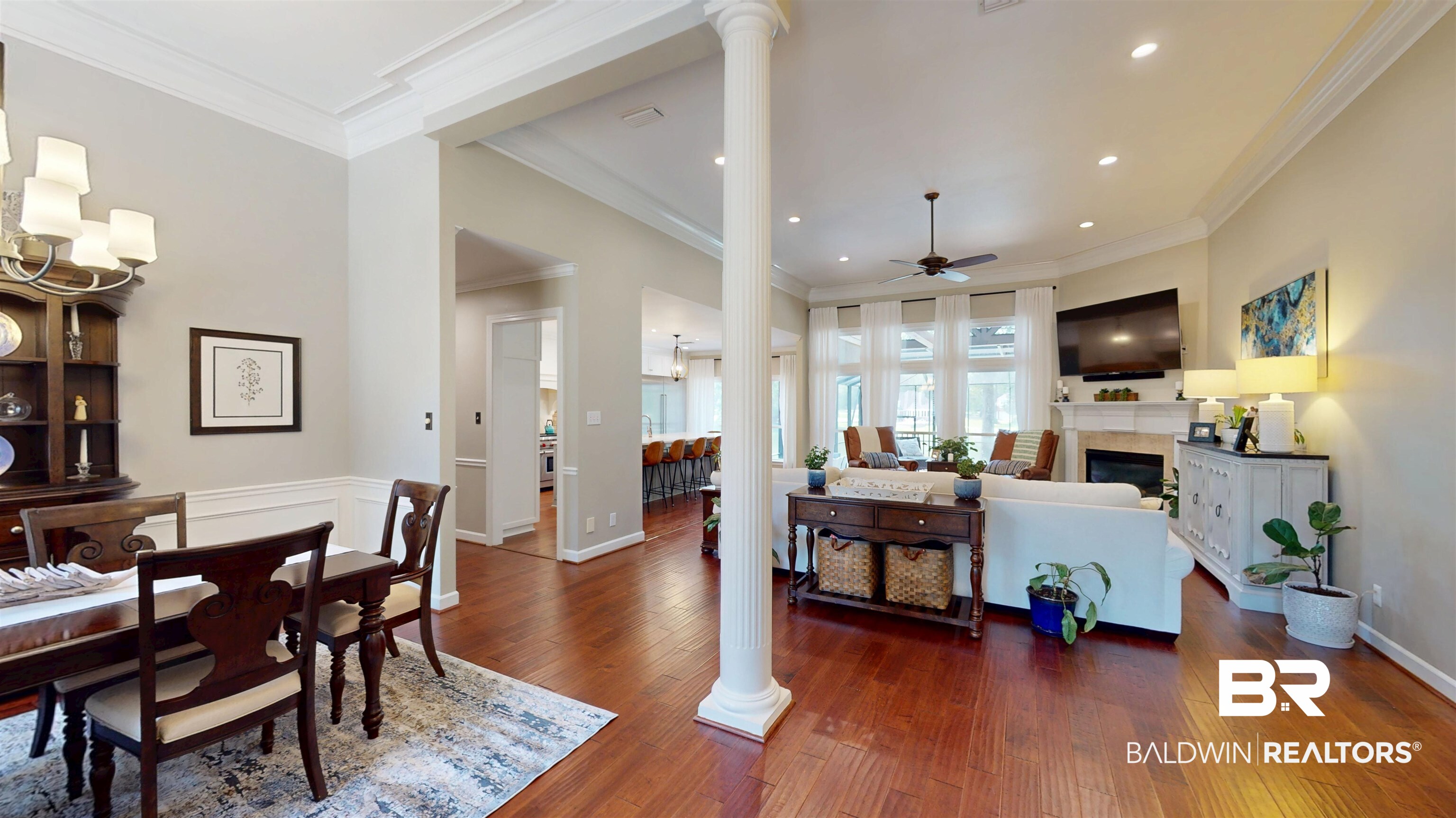 8775 Dawes Lake Road North Mobile, AL 36619 - Photo 17 of 59 Dining room featuring a ceiling fan, dark wood finished floors, decorative columns, crown molding, and a fireplace
