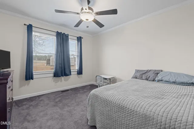 a view of a hallway with wooden floor and a bathroom