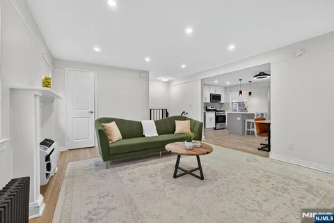 a living room with furniture and a dining table with wooden floor