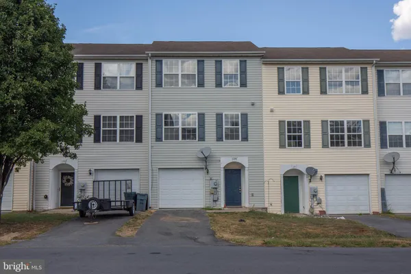 a front view of a building with cars parked