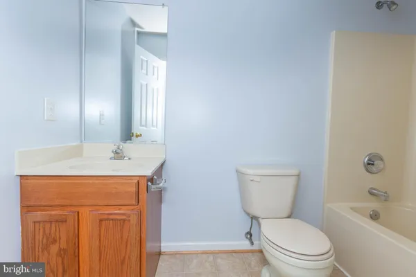 a bathroom with a granite countertop toilet a sink and a mirror