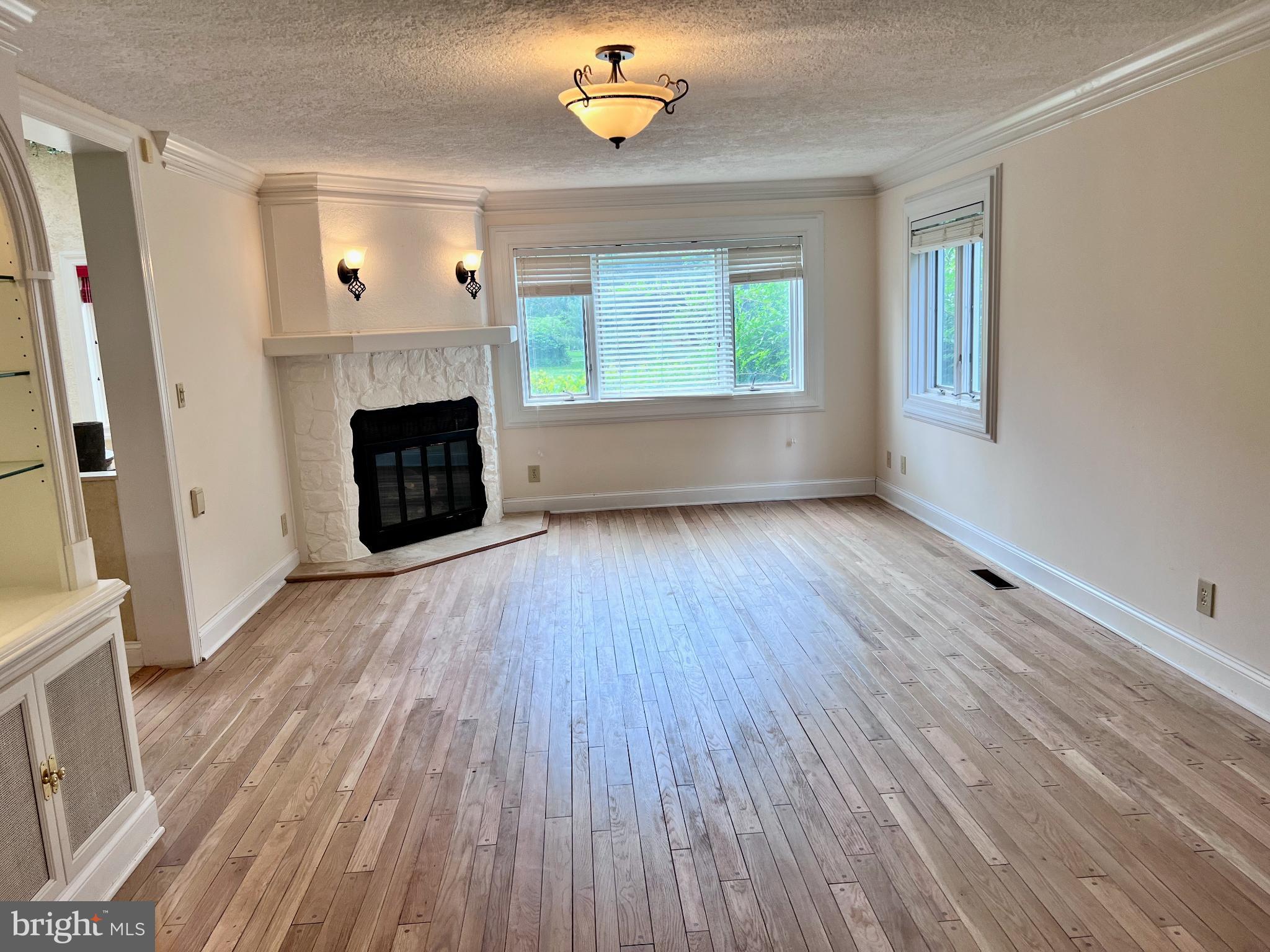15729 Holly Grove Road Silver Spring, MD 20905 - Photo 26 of 83 a view of an empty room with wooden floor fireplace and a window