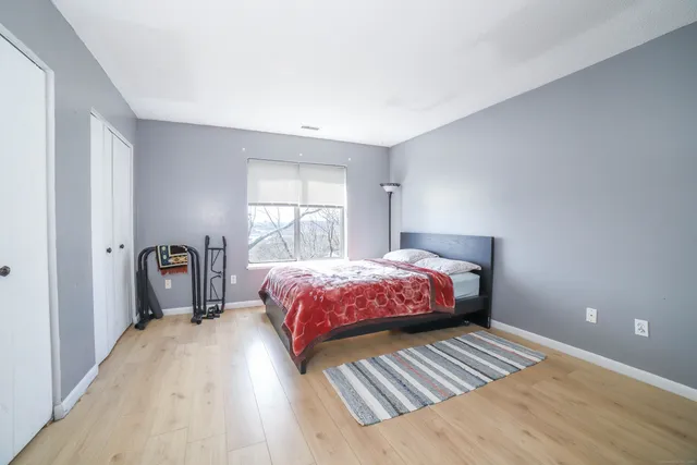 a bedroom with a bed and wooden floor