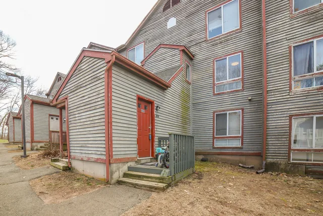a view of a house with a small yard and wooden fence