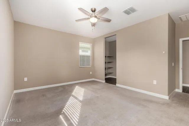 an empty room with windows and fan