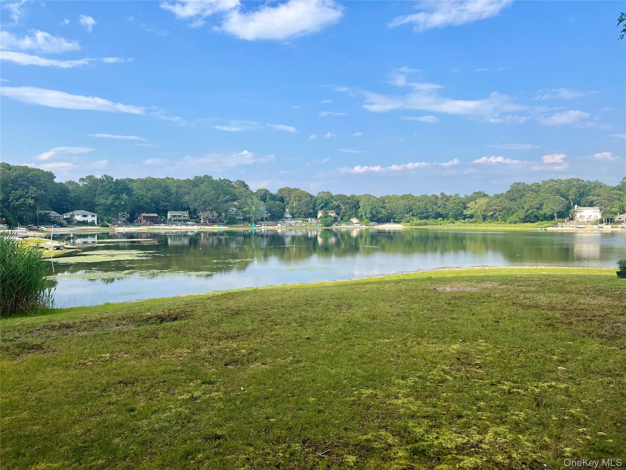 230 Lakeside Trail Ridge, NY 11961 - Photo 22 of 33 a view of a lake with houses in the back
