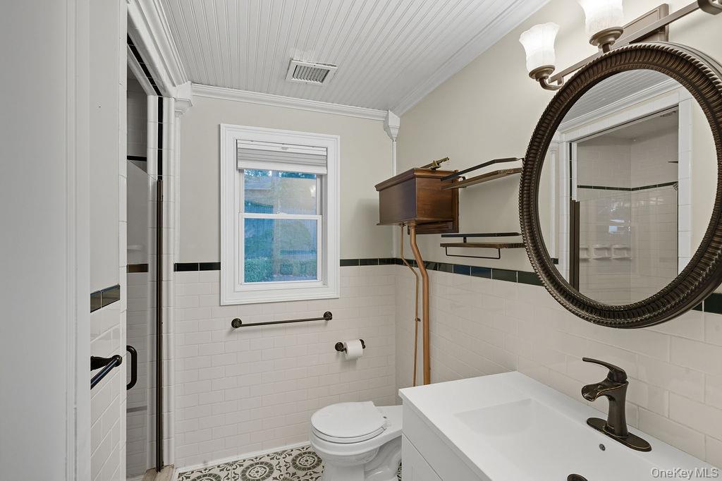 230 Lakeside Trail Ridge, NY 11961 - Photo 10 of 33 a bathroom with a sink a mirror a toilet and a window