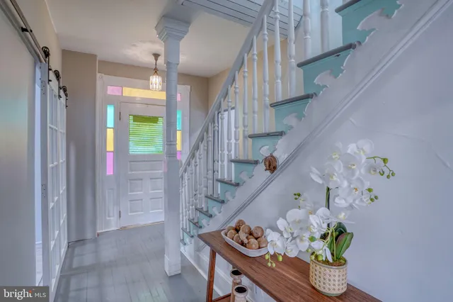 a kitchen with stainless steel appliances granite countertop a sink dishwasher a stove top oven a refrigerator with white cabinets and wooden floor