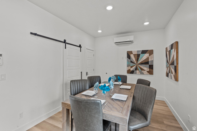 1122 South 1790th West, Unit 1 St. George, UT 84770 - Photo 10 of 37 Dining area featuring light wood-finish flooring, recessed ceiling lighting, a barn door on a black rail, and a wall-mounted climate control unit