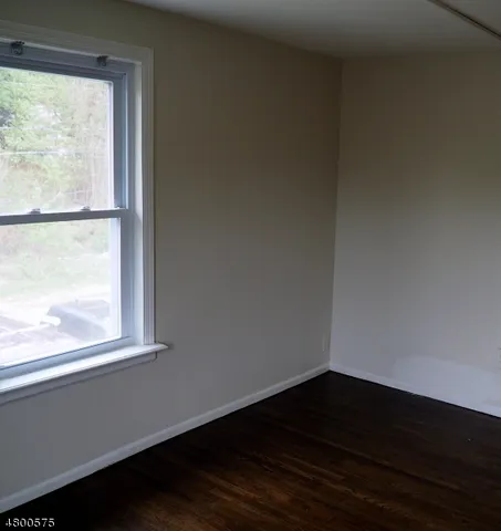 a view of a small space with wooden floor and a window